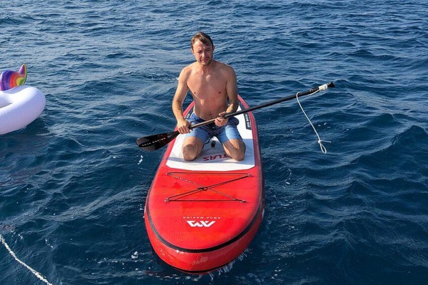 Un uomo pagaia in kayak rosso su un corpo d'acqua. 2