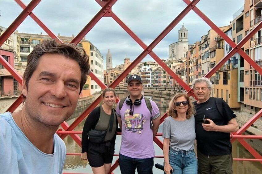 A group of people standing on a bridge with a cityscape in the background. 3