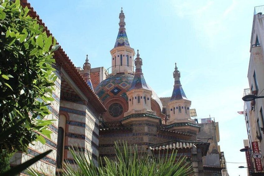Un bâtiment historique doté de coupoles et de tours richement décorées, entouré de constructions urbaines. 5