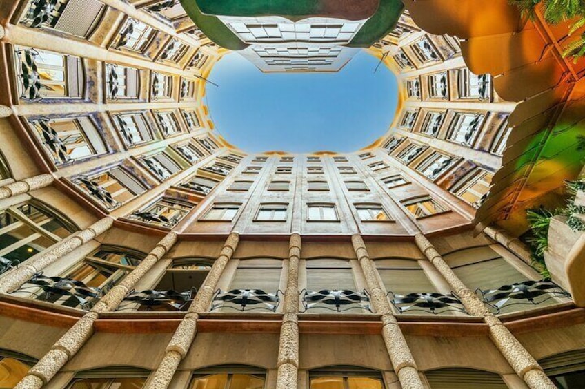 A building with a unique architectural design featuring multiple levels of balconies and a central atrium. 2