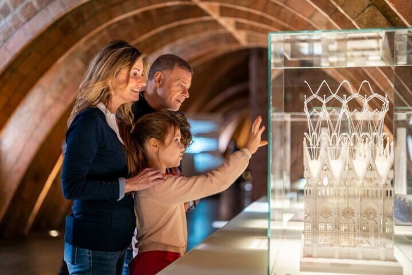 A family looking at a display of glassware in a museum. 5