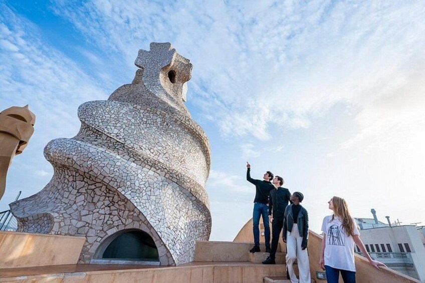 A spiraling stone structure with people standing around it. 3