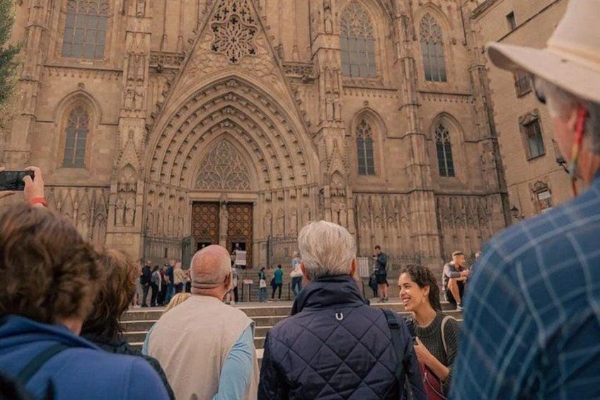 A historic cathedral with intricate architecture, a large arched entrance, and a crowd of visitors. 2