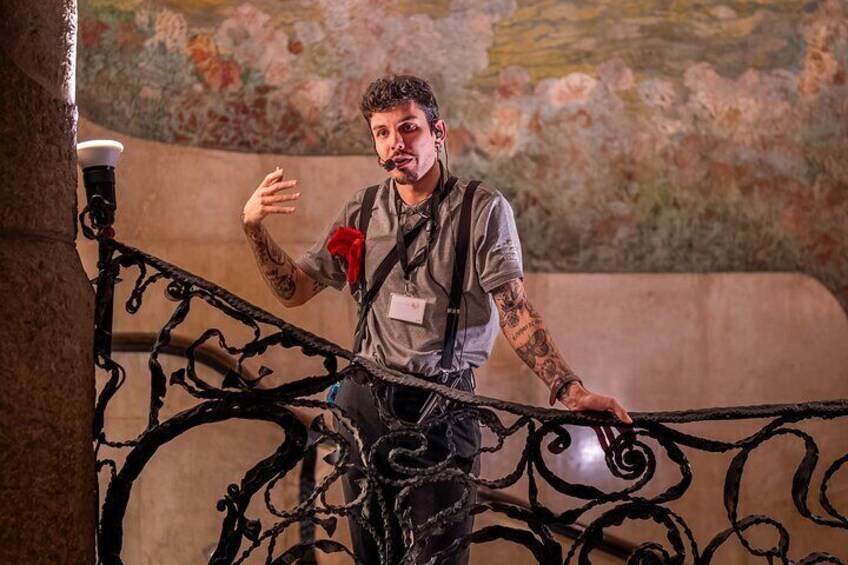 A person standing on a wrought iron staircase with a floral mural in the background. 4