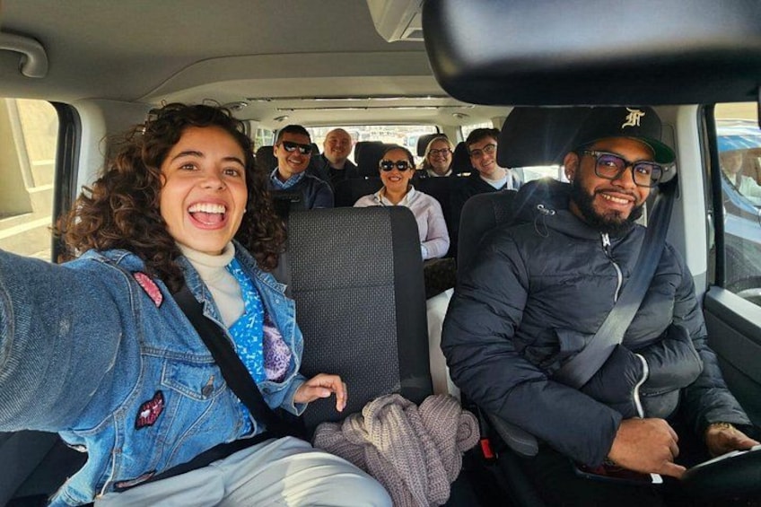 A vehicle interior with passengers seated. 5
