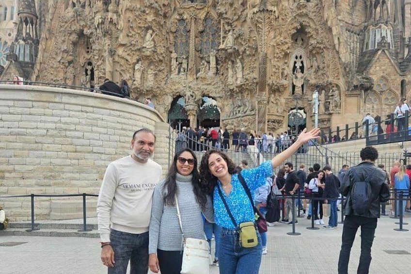 A historic cathedral with intricate carvings, a stone wall, and a crowd of people. 2