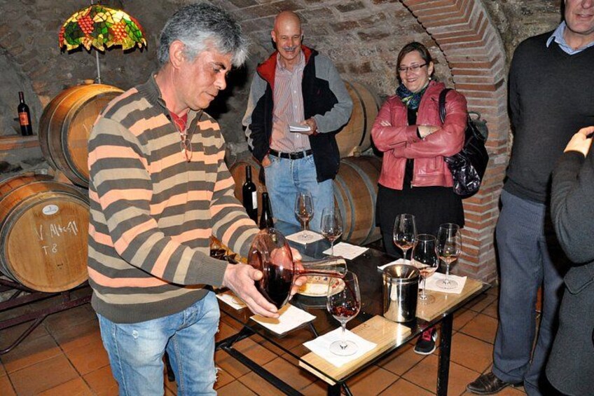 A man pouring wine into glasses at a tasting event. 1