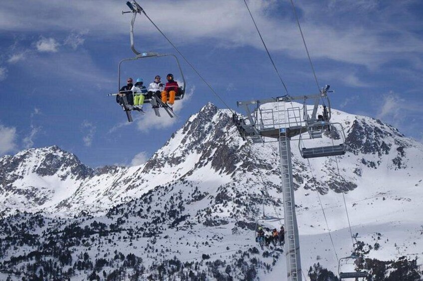 A ski lift with skiers ascending a snow-covered mountain. 5
