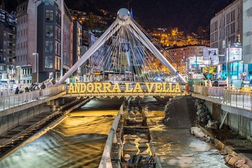 A bridge with the text 'ANDORRA LA VELLA' and a cityscape in the background. 5