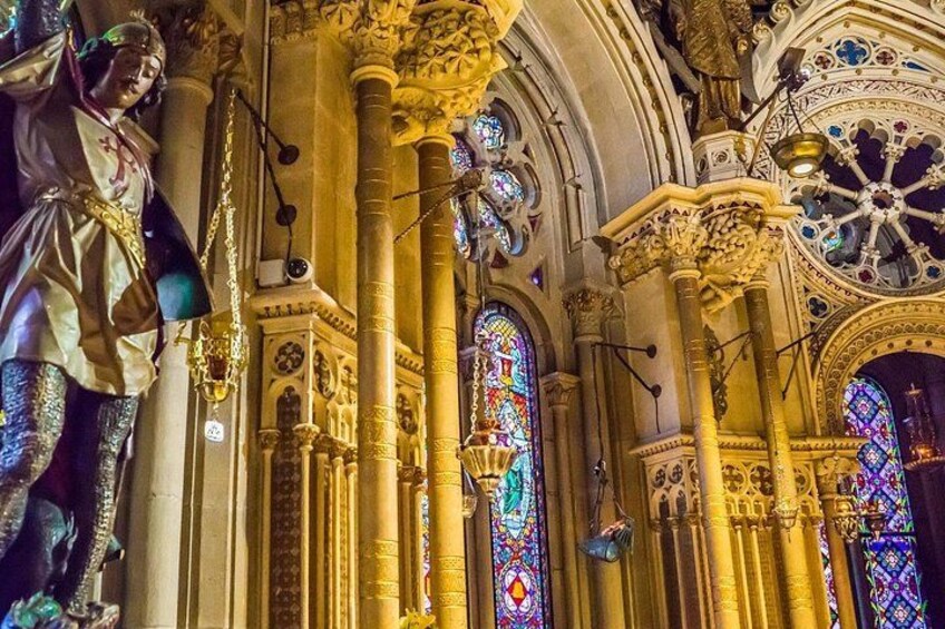 A cathedral interior with ornate columns, stained glass windows, and religious statues. 4