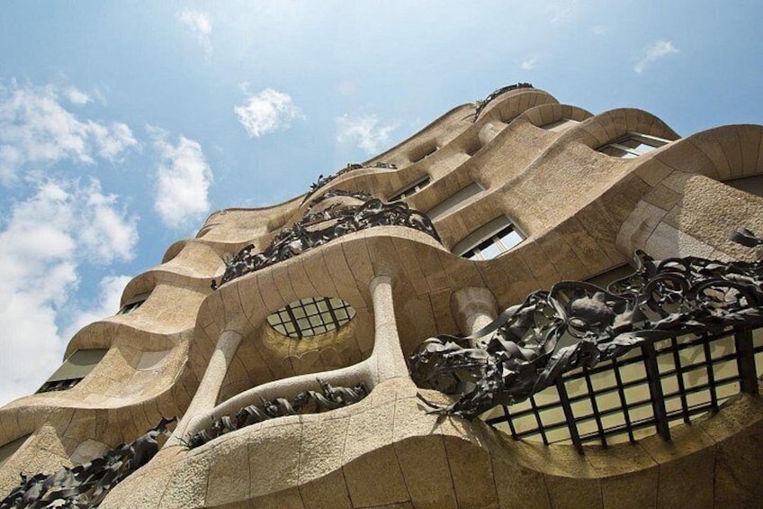 Un edificio con un diseño arquitectónico único, con líneas curvas y balcones. 3