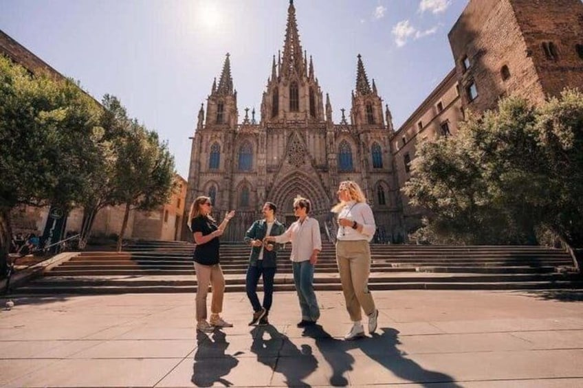 A group of people standing in front of a cathedral with a large, ornate facade and a tall spire. 4