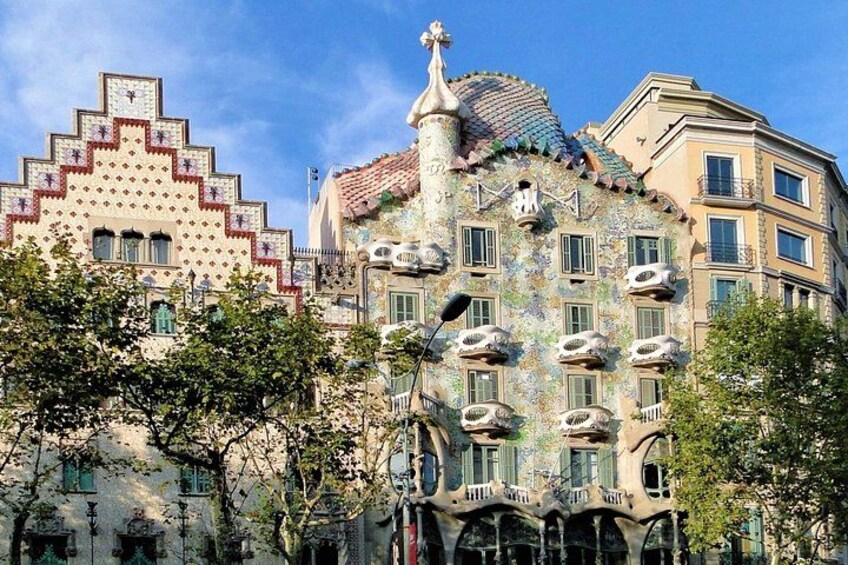 Un edificio de arquitectura distintiva, con balcones, ventanas y una torre. 2