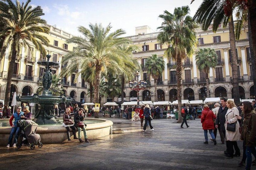 Une place publique animée, agrémentée de palmiers, d’une fontaine et de bâtiments historiques. 5