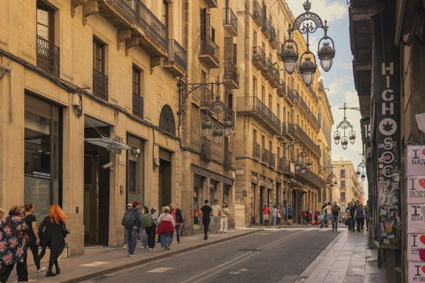 A busy urban street with pedestrians, historic buildings, and street lamps. 2
