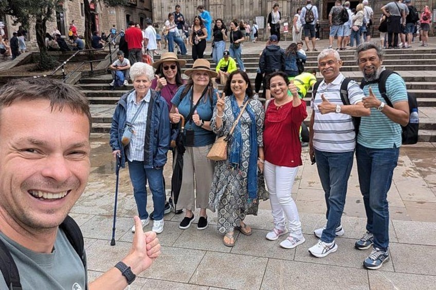 A group of people posing for a photo in a public square with steps and a building in the background. 2