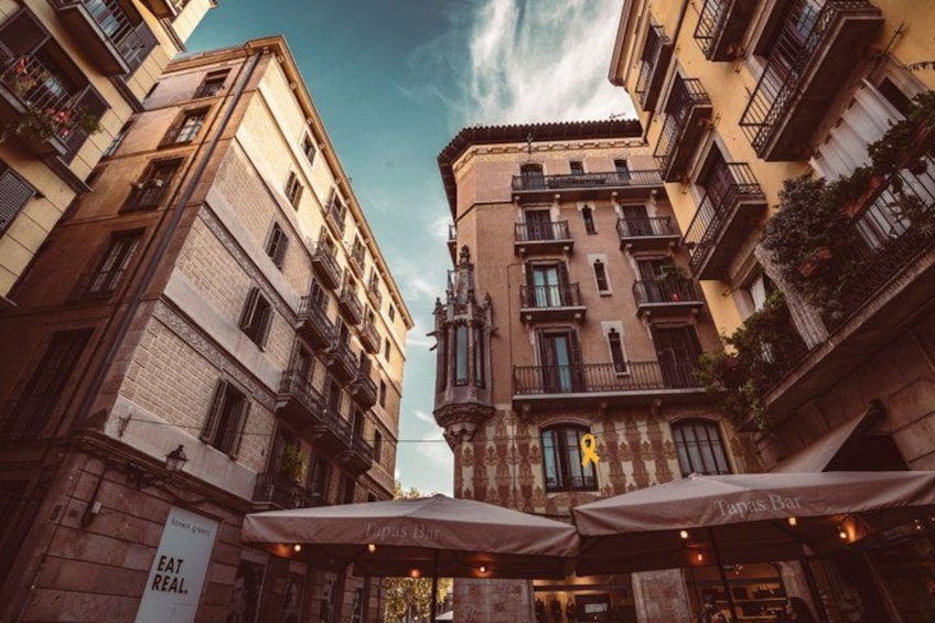 A street with buildings, outdoor seating, and a sign that says 'EAT REAL.' 4