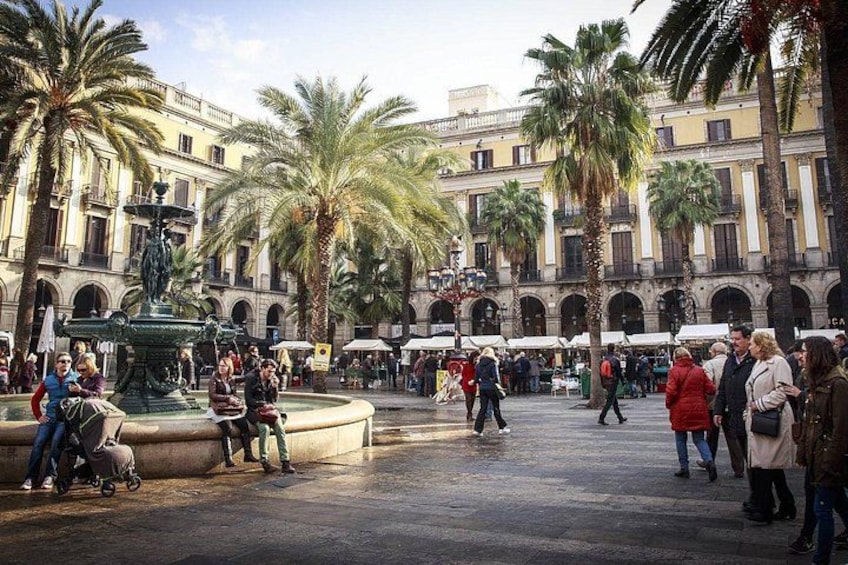 A bustling public square with palm trees, a fountain, and historic buildings. 5