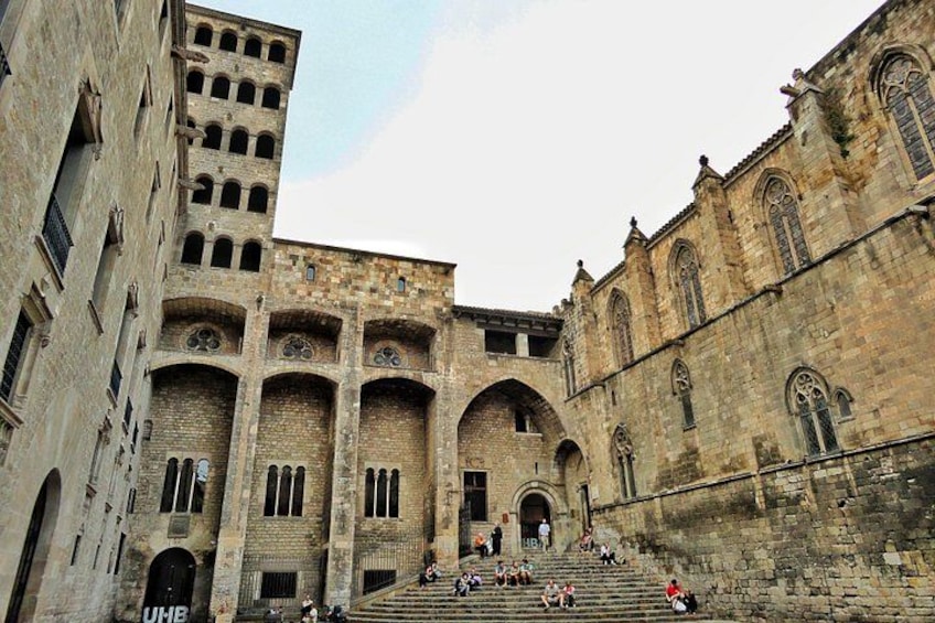 A historic building with arched windows and a staircase leading to an entrance. 3