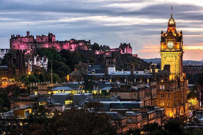 A cityscape with a prominent clock tower, historic buildings, and a castle in the background. 5