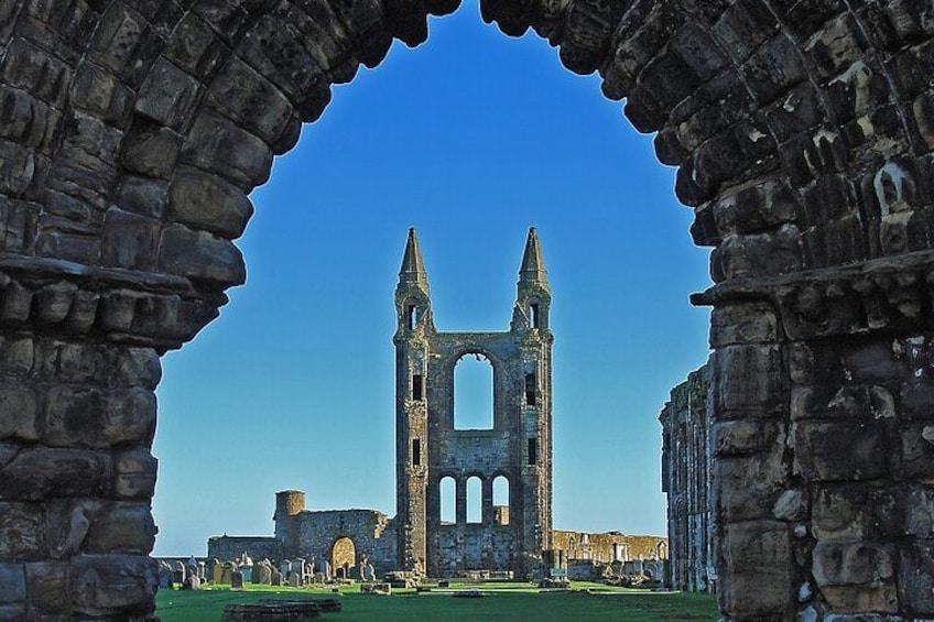 Un arc en pierre antique encadre les ruines d’une église, dont le clocher s’élève vers le ciel. 3