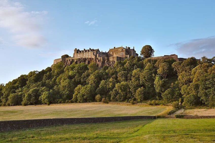 A historic castle on a hill, surrounded by lush greenery. 3