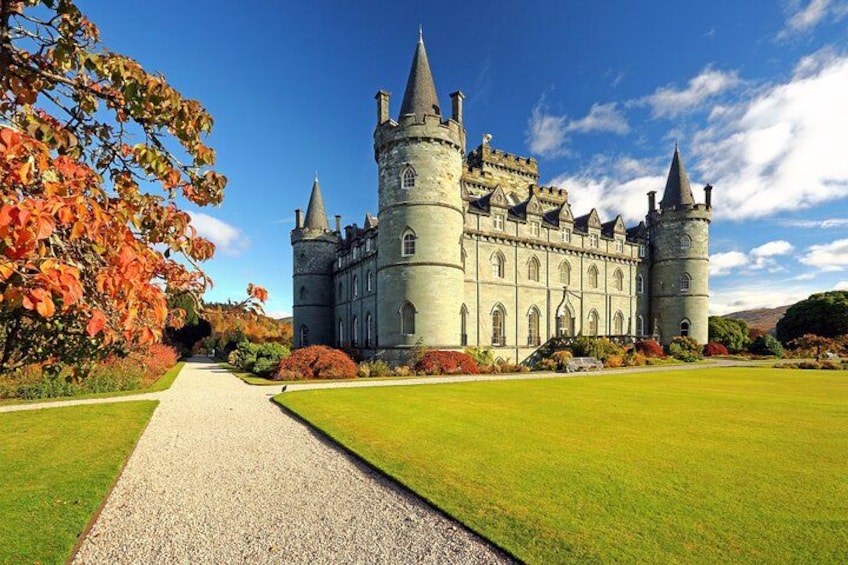 Un grand château doté de nombreuses tours et d’une pelouse bien entretenue. 1