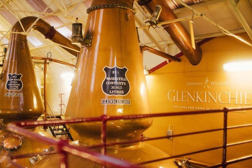 Large copper distillation columns with labels indicating they contain whisky. 5