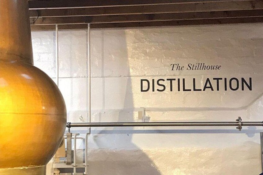 Un appareil de distillation doté d’un grand récipient en cuivre et d’une étiquette indiquant : « The Stillhouse DISTILLATION ». 2