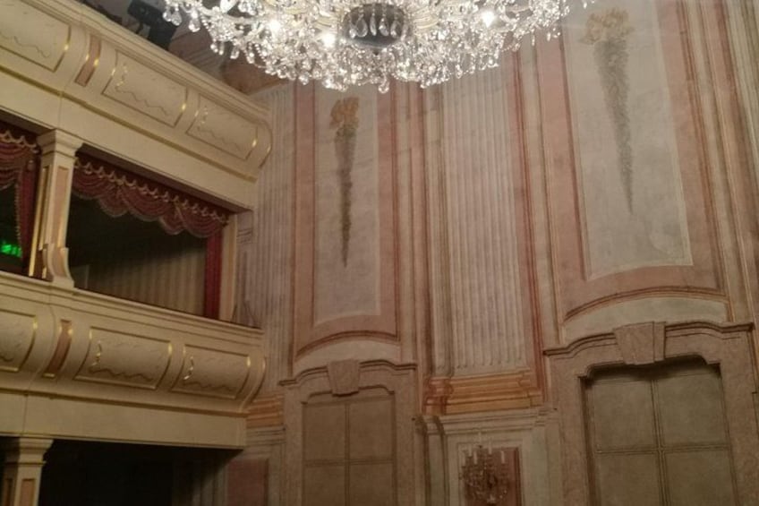Ornate architectural details, a chandelier, and a balcony. 4