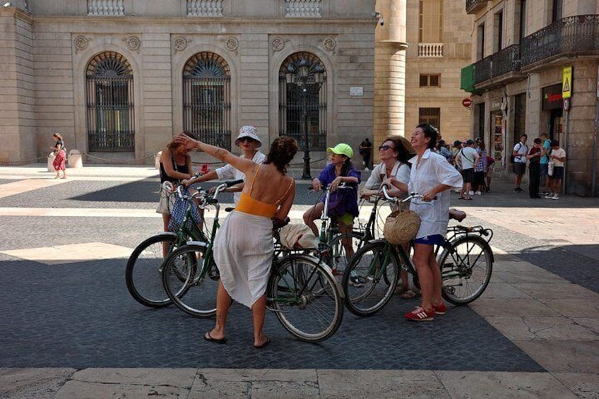 A group of people with bicycles in a public square. 3
