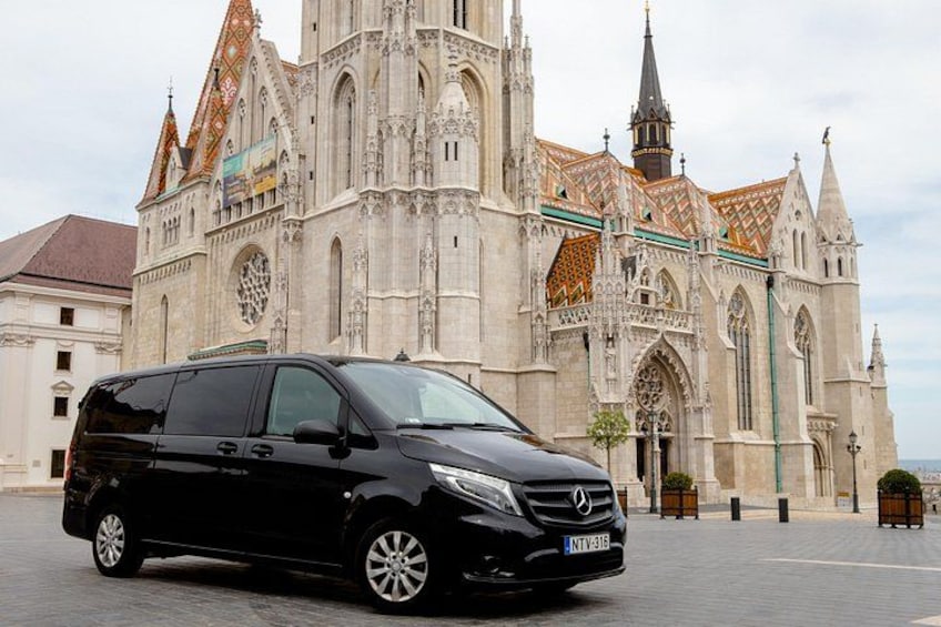Un fourgon noir était garé devant une cathédrale historique, dont l’architecture était riche en détails et qui était surmontée d’une haute flèche. 3
