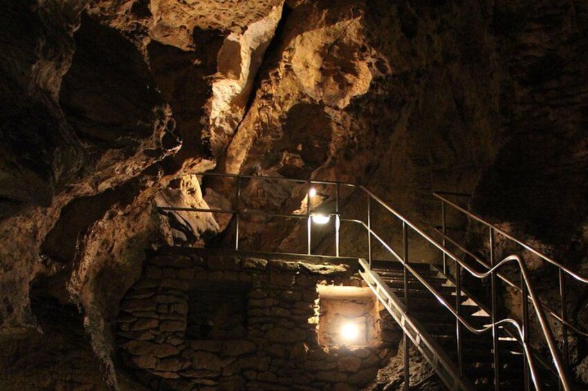 Une grotte avec un escalier menant à une chambre en pierre. 2
