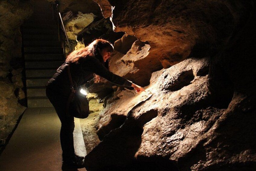 Une personne examine des formations géologiques dans une grotte à l’aide d’une lampe de poche. 5