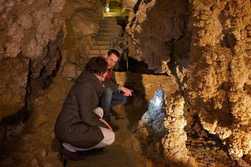 Une personne accroupie dans une grotte, avec un escalier menant vers le haut. 4