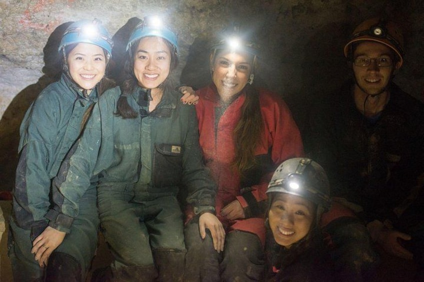 A group of people in protective gear and helmets, likely engaged in a cave exploration or spelunking activity. 4