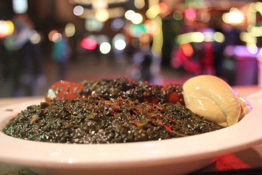 A plate of food with a dark, textured dish and a dollop of cream on the side. 5