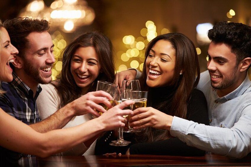 Un groupe de personnes trinquant avec des boissons dans un bar. 5
