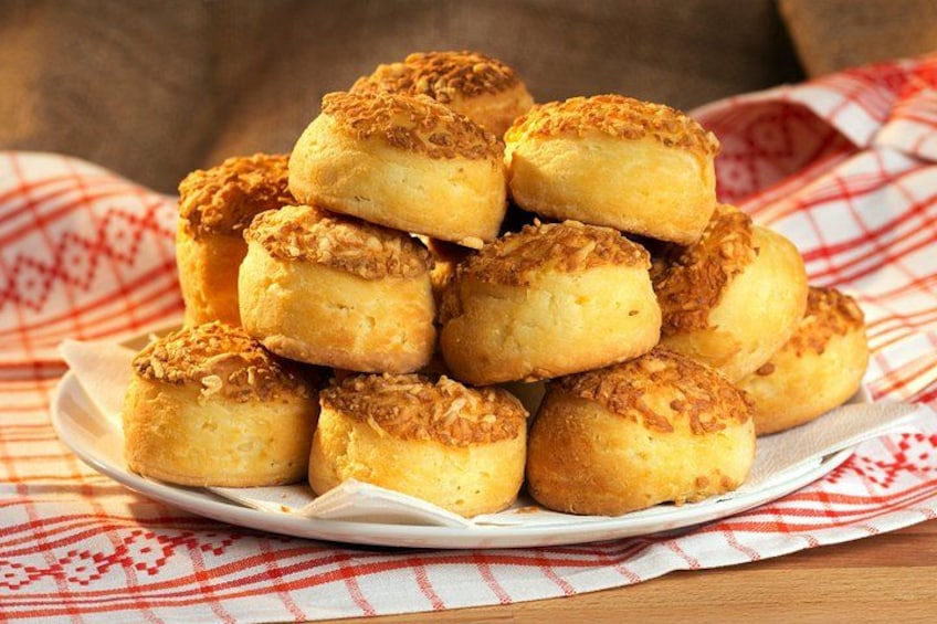 Une pile de viennoiseries dorées et croustillantes, disposées sur une assiette blanche, le tout posé sur une nappe à carreaux rouges et blancs. 2