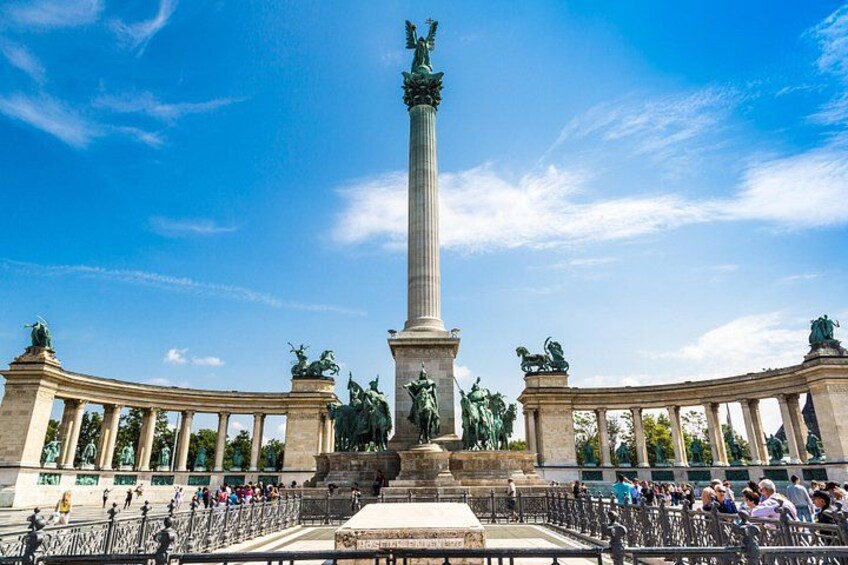 Een groot monument met beelden, een fontein en een klassiek gebouw met kolommen. 1