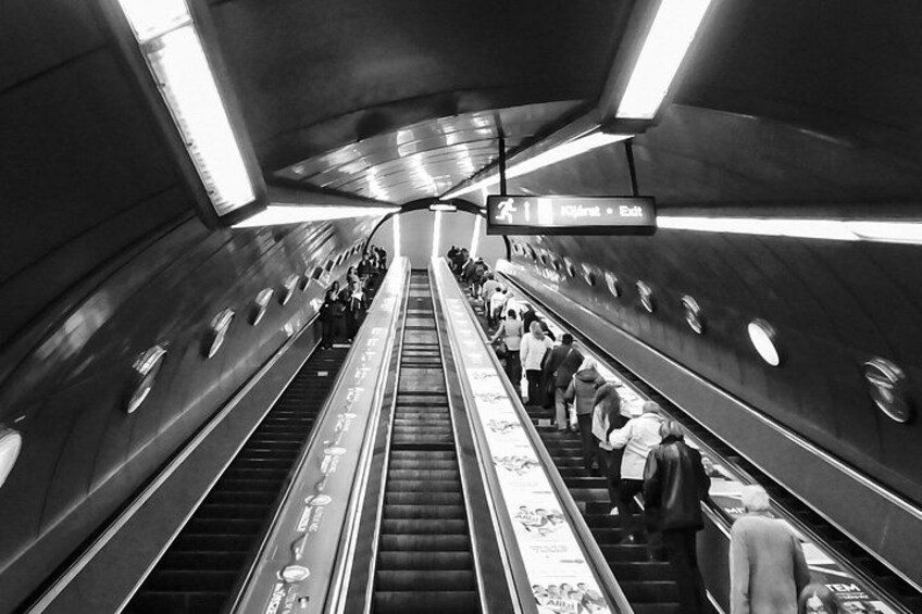 Een roltrap in een metrostation, met mensen die omhoog en omlaag gaan. 5