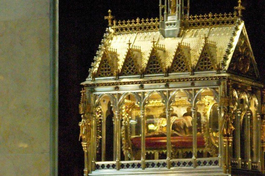 A golden, ornate structure with a pointed roof and arched windows. 2