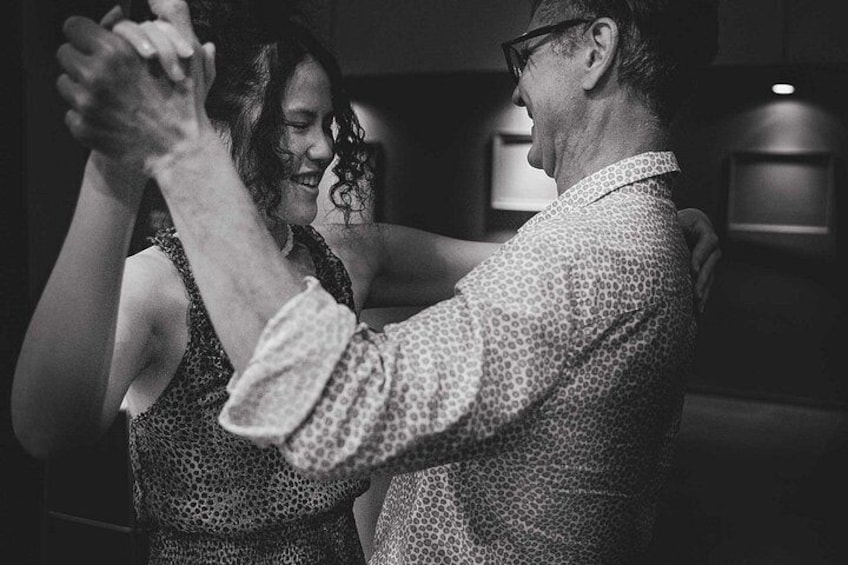 Two people dancing, a man and a woman, in a dimly lit indoor setting. 2