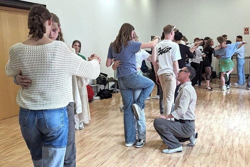 A dance class in a room with wooden floors and mirrors. 5
