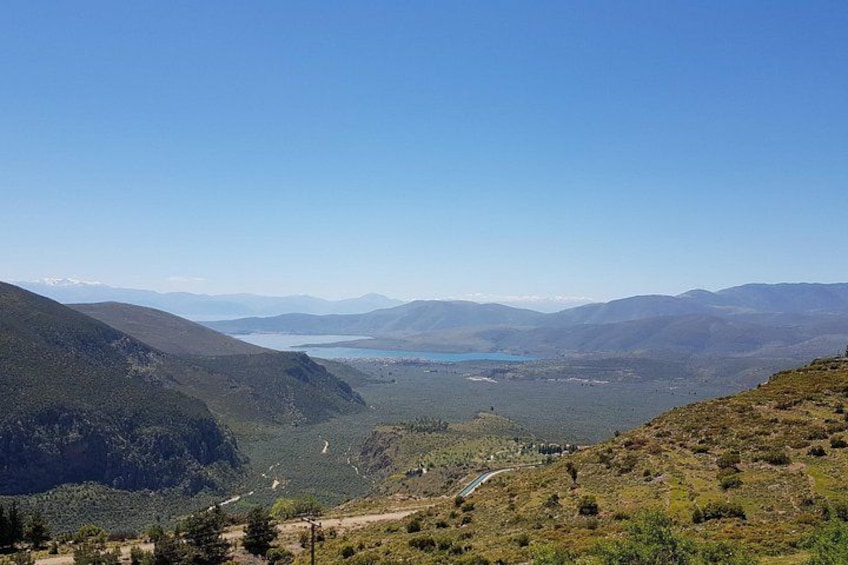 Een bergachtig landschap met een meer en een slingerende weg. 5