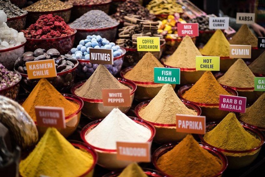 A variety of spices displayed in glass containers with labels. 2