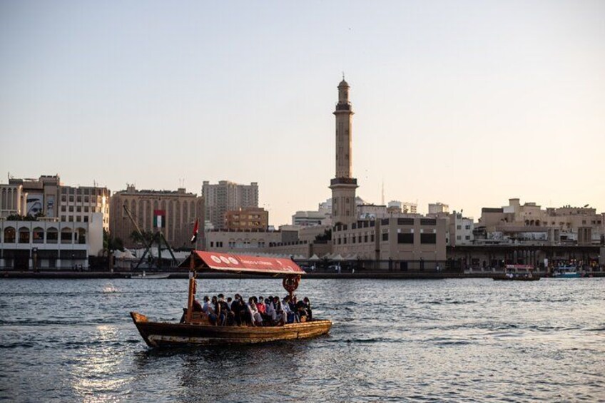 Un bateau transportant des passagers sur une rivière, un minaret imposant et des bâtiments en arrière-plan. 3