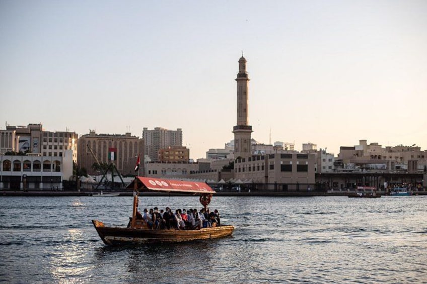 A boat with passengers on a river, a tall tower, and a cityscape with buildings. 3