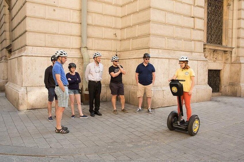 A group of people standing on a paved area with a building in the background. 4
