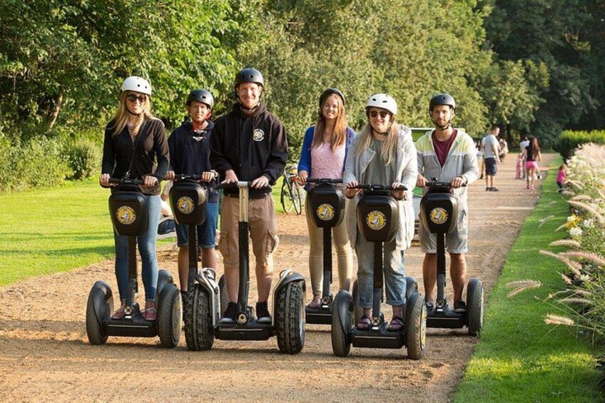 A group of people on segways on a dirt path in a park. 3